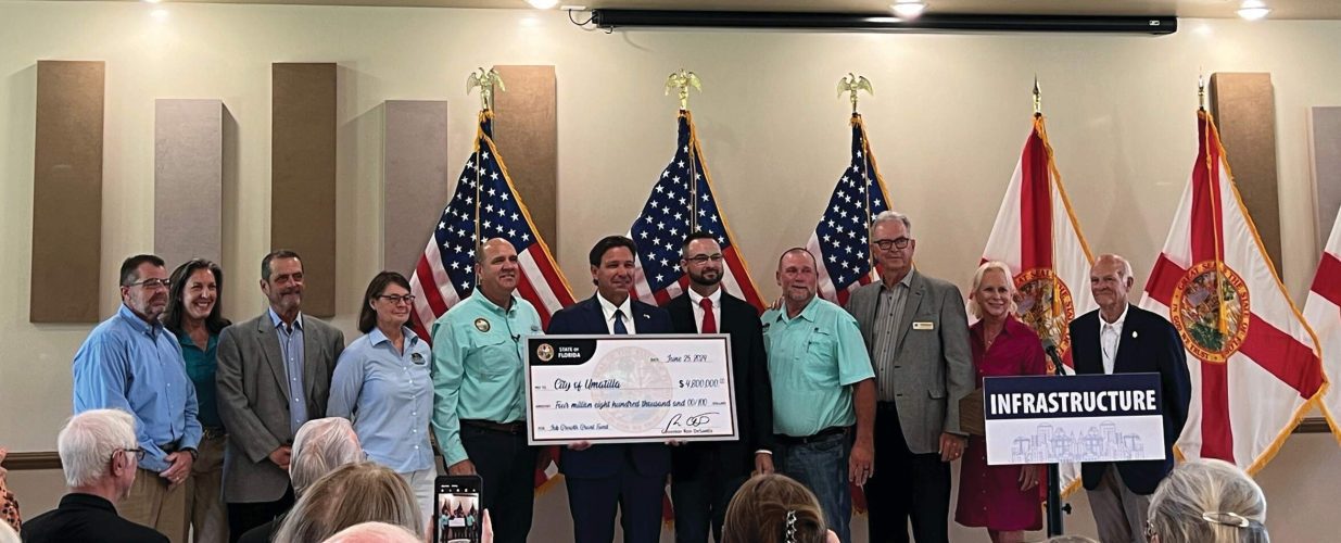 Governer Ron DeSantis presenting a check to the City of Umatilla with Halff in June 2024 for grant funding
